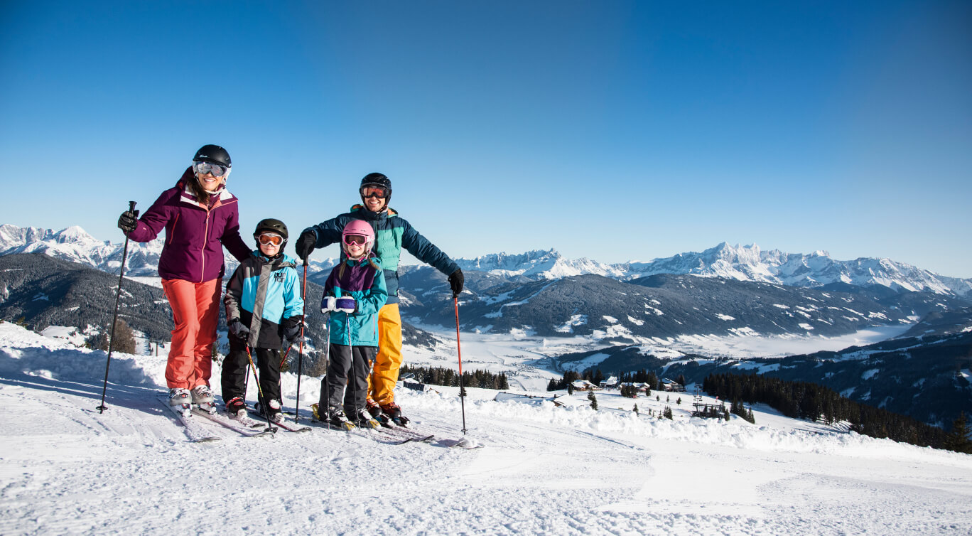 Familie mit Kind fährt Ski auf breiten und sicheren Skipisten in Flachau